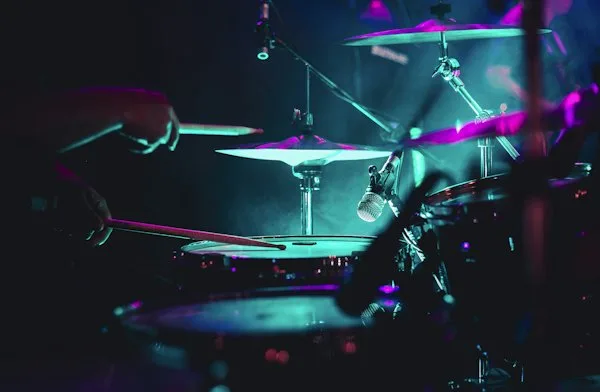 Drum kit lit in teal and magenta