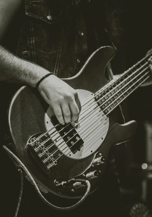 Close-up of hands playing a bass guitar
