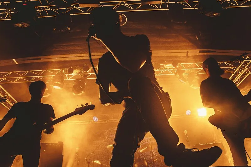 Band silhouetted against orange stage lights