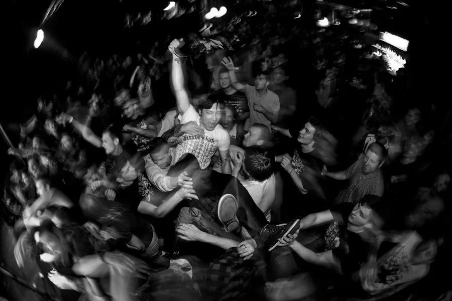 Crowd surging in a black-and-white mosh pit