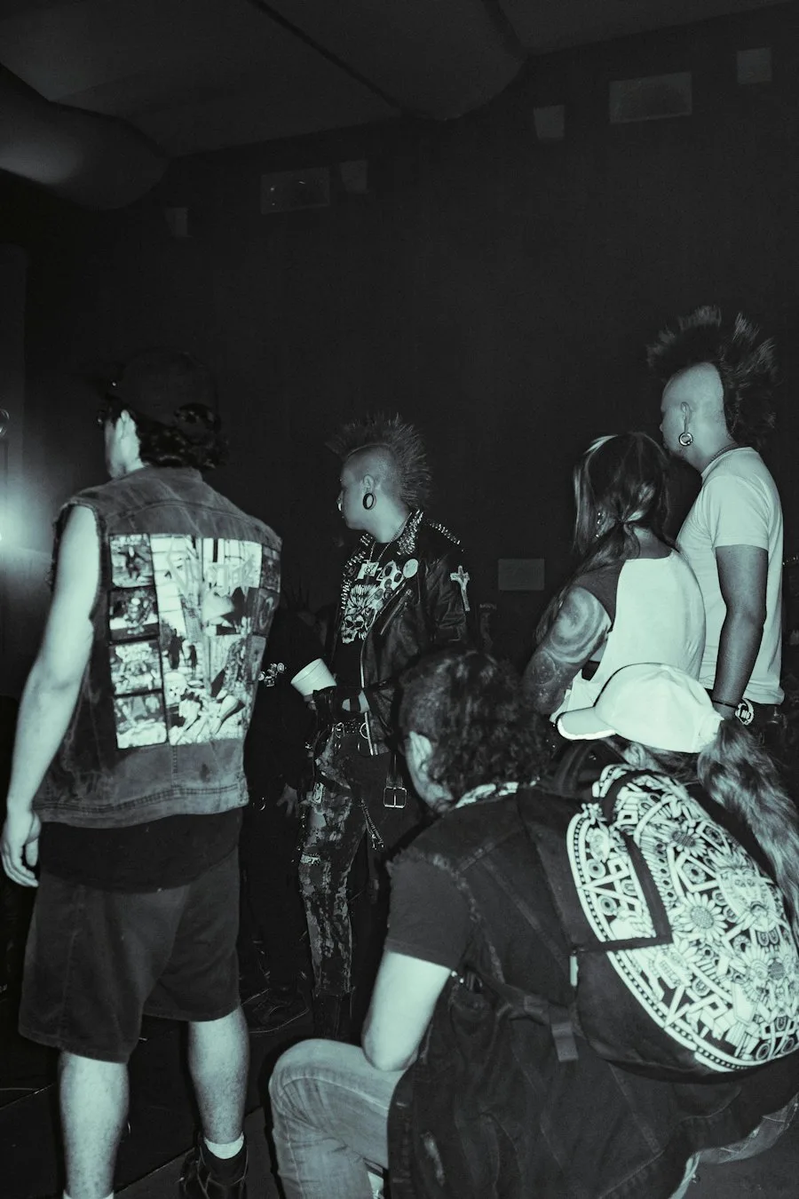 Fans in patched jackets in a packed black-and-white pit